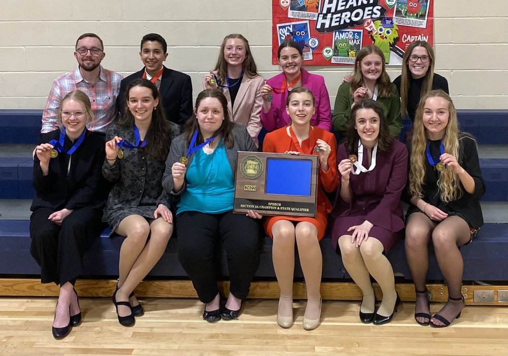 Speech students holding their awards and section plaque seated in two rows